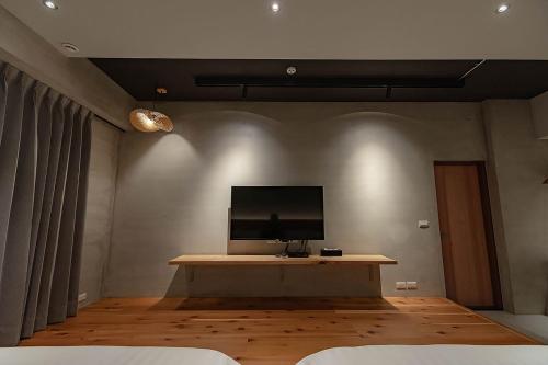 a room with a table with a television on the wall at 全村的希望Hope of village in Dongshan