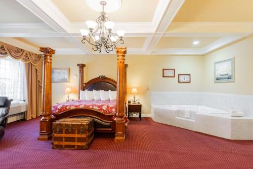 a bedroom with a bed and a tub and a chandelier at Best Western White House Inn in Bangor