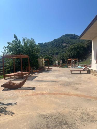 a group of picnic tables and benches in a park at MonteSoprano Agriturismo - Resort - Spa - Gym -Camping - Suite in Capizzi