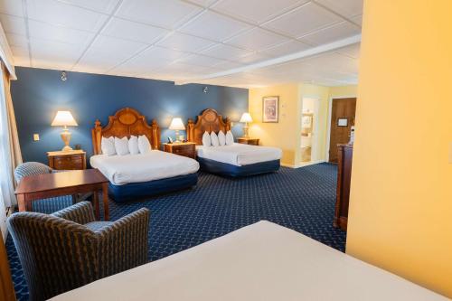 a hotel room with two beds and a desk and chairs at Best Western White House Inn in Bangor