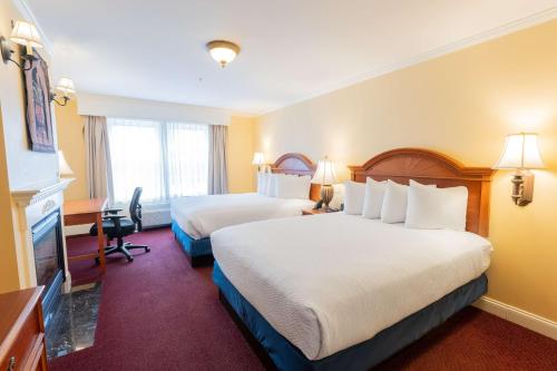 a hotel room with two beds and a desk at Best Western White House Inn in Bangor