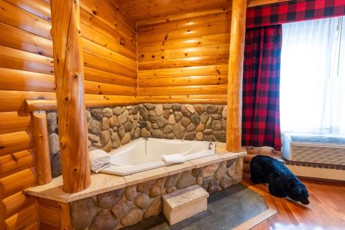a bathroom with a tub in a log cabin at Best Western White House Inn in Bangor