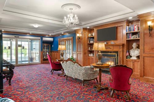 a living room with a table and chairs and a television at Best Western White House Inn in Bangor
