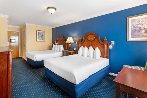two beds in a hotel room with blue walls at Best Western White House Inn in Bangor