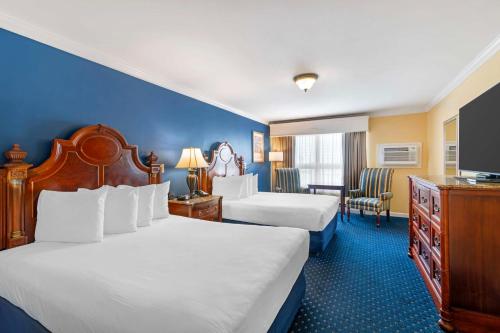a hotel room with two beds and a desk at Best Western White House Inn in Bangor