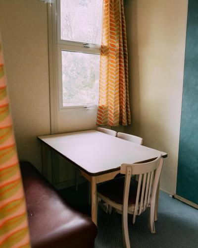 a table and a chair in a room with a window at Camping Santa Elena in Lloret de Mar
