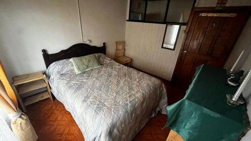 a small bedroom with a bed and a door at Sazón Casero in Constitución