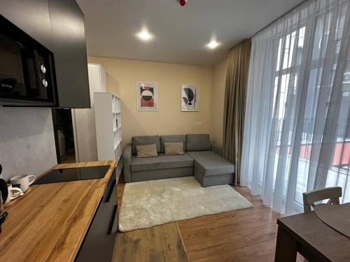 a living room with a couch and a large window at Smart House Apartments in Lviv