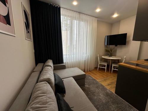 a living room with a couch and a table with a television at Smart House Apartments in Lviv