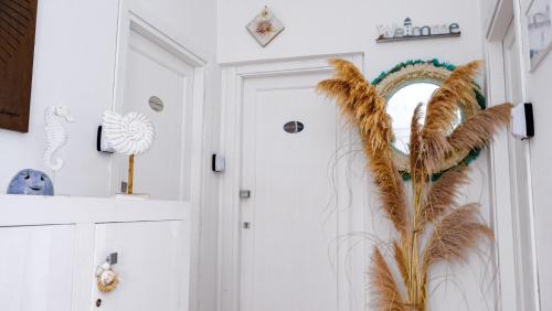 a hallway with a door with a feather wall art at Rooms Apartaments Santa Teresa in Capo Testa