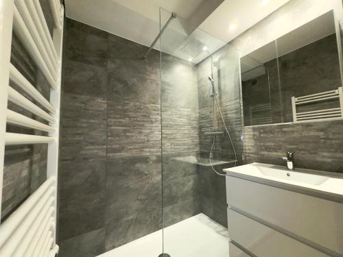 a bathroom with a glass shower and a sink at Spacious new studio and terrace in Juan-les-Pins