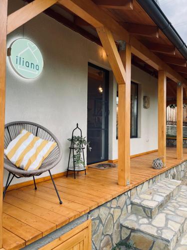 a wooden deck with a chair on a house at Casa iliana in Breaza de Jos