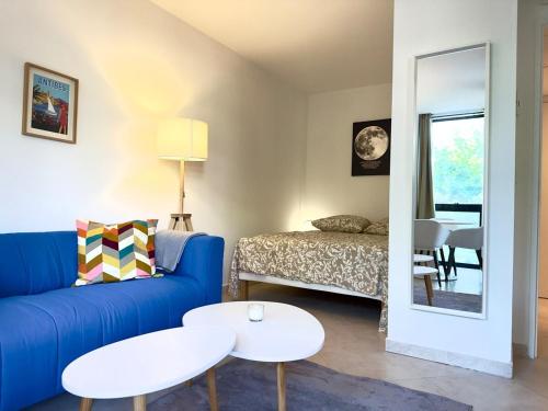 a living room with a blue couch and a table at Spacious new studio and terrace in Juan-les-Pins