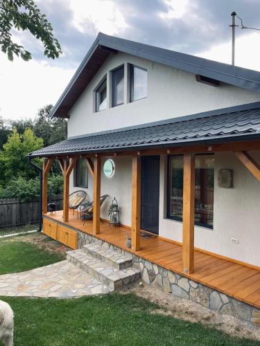 a house with a large wooden deck at Casa iliana in Breaza de Jos