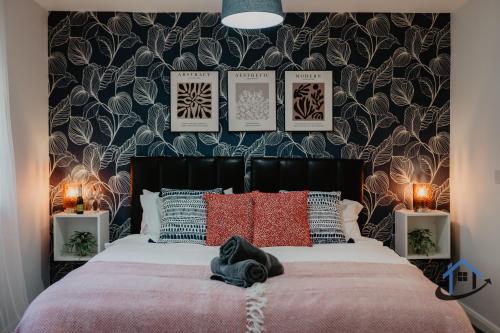 a bedroom with a large bed with red pillows at 4 Clovelly Court, Derby, DE22 1GS in Derby