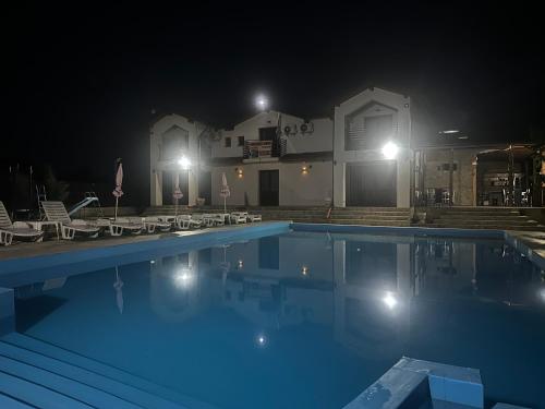 a swimming pool in front of a house at night at Pensiunea Maria Agighiol in Agighiol