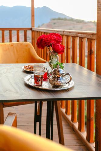 a table with a vase of roses on a balcony at Atlas Smile Retreat in Ouirgane