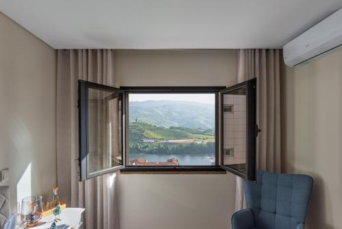 a room with a window with a view of a lake at Feel Discovery Casa do Alfaiate in Peso da Régua