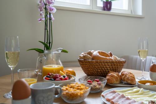 a table with breakfast foods and drinks and eggs and bread at Studio Apartment Graz Schloss Eggenberg in Graz