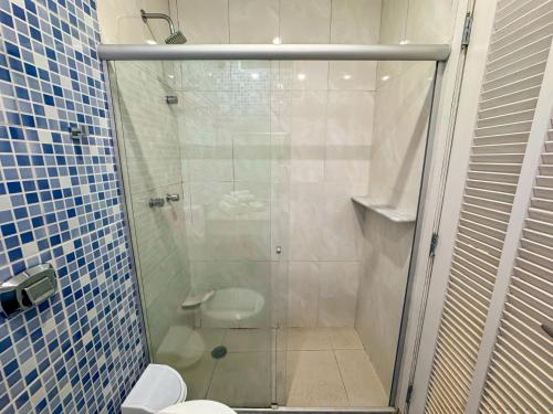 a bathroom with a glass shower with a toilet at Hotel Nacional Inn Guarujá in Guarujá