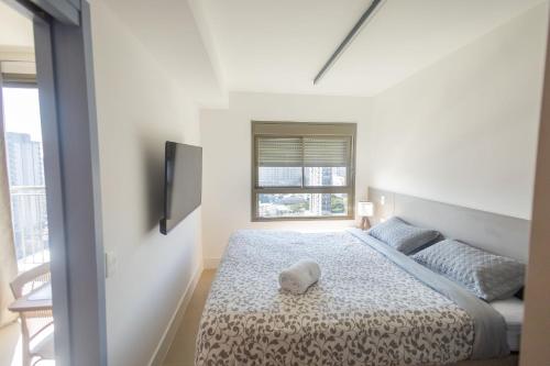 une chambre blanche avec un lit et une télévision dans l'établissement Apartamentos de luxo Campo belo perto do aeroporto, à São Paulo