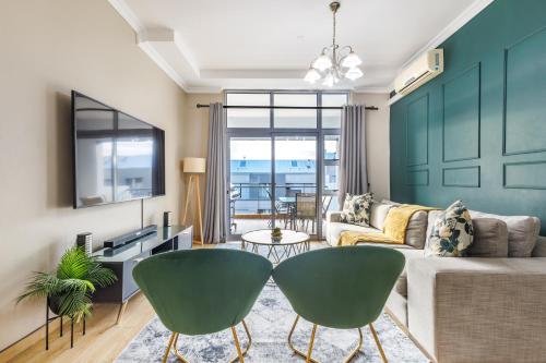 un soggiorno con un divano, un tavolo e delle sedie di Elegant Emerald Stay at Ridgeton Modern Two Bedroom Apartment in the Heart of Umhlanga Ridge Sleeps 6 a Durban