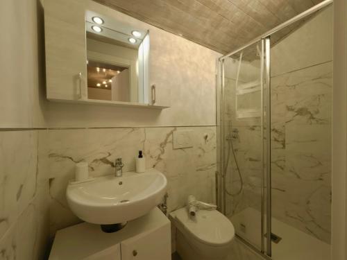 a bathroom with a sink and a shower and a toilet at Caruggi Lifestyle - mare 200m - AC - WiFi in Albissola Marina