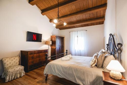 a bedroom with a large bed and a chair at Villa Le 12 Querce in Castel di Mezzo