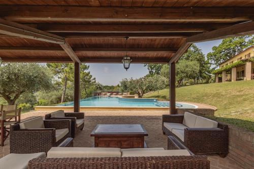 an outdoor patio with chairs and a table and a swimming pool at Villa Le 12 Querce in Castel di Mezzo