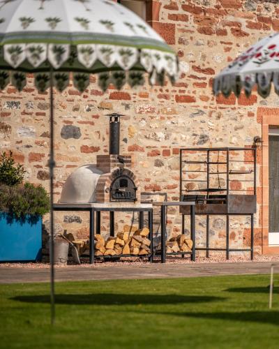 a brick building with a pizza oven in front of it at Newhall Mains in Resolis