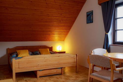 a bedroom with a bed and a table and chairs at Ubytování U Anděla in Raby