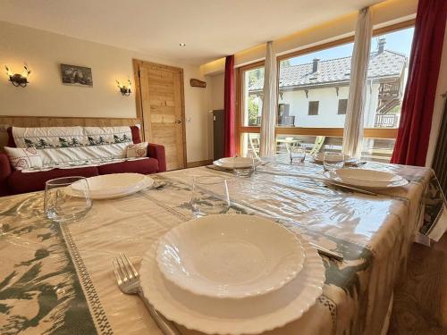une table avec des assiettes et des verres au-dessus dans l'établissement Appartement cosy au cœur de Praz-Sur-Arly - 5 pers, proche centre et pistes, parking et casier ski - FR-1-603-35, à Praz-sur-Arly