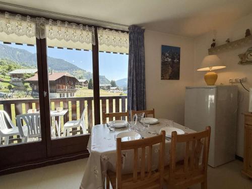 une salle à manger avec une table et un balcon dans l'établissement Studio cabine à 700m de Praz-Sur-Arly, navettes gratuites, parking, wifi et ménage inclus - FR-1-603-4, à Praz-sur-Arly