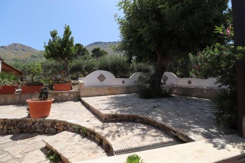 a garden with a tree and a white fence at EVEN HAVEN Baglio in San Vito lo Capo
