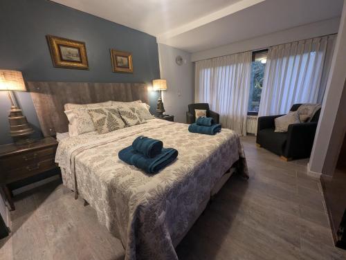 a bedroom with a bed with two blue towels on it at Citizen Kane Lodge - Hospedaje Gourmet in San Carlos de Bariloche