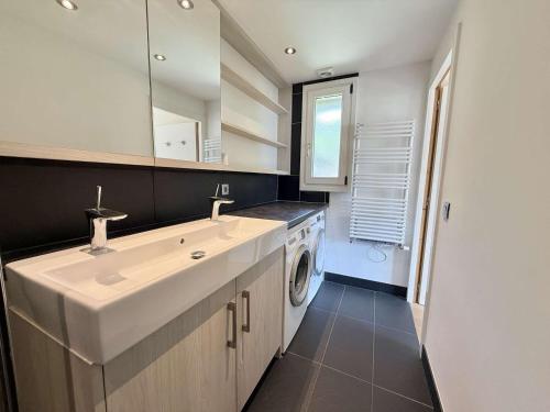 a bathroom with a sink and a washing machine at Appartement cosy au cœur de Praz-Sur-Arly - 5 pers, proche centre et pistes, parking et casier ski - FR-1-603-35 in Praz-sur-Arly