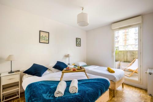 ein Schlafzimmer mit zwei Betten und einem Fenster in der Unterkunft BnGo I Immense Terrasses I 3 chambres, garage, 9 pers in Villeurbanne