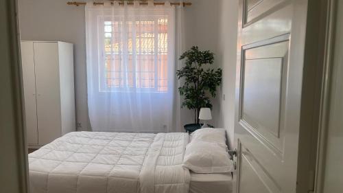 a white bedroom with a bed and a window at Residencial Sky Lounge in Lisbon