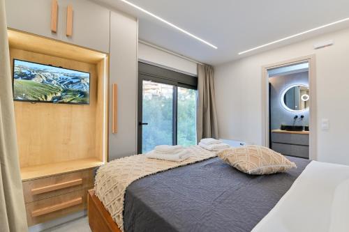 a bedroom with a bed and a large window at September15 Suites- Meganisi in Meganisi
