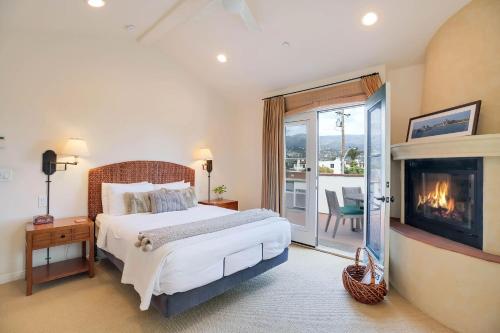 een slaapkamer met een groot bed en een open haard bij Casa Cielo in Santa Barbara
