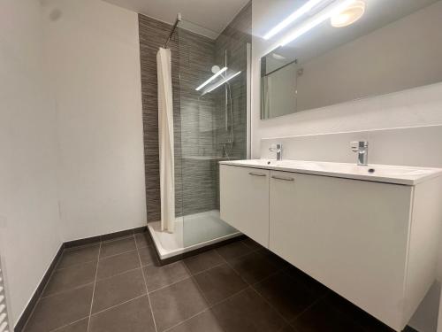 a white bathroom with a sink and a shower at Modern 2 Bedroom Apartment for 6 - City Center in Brussels