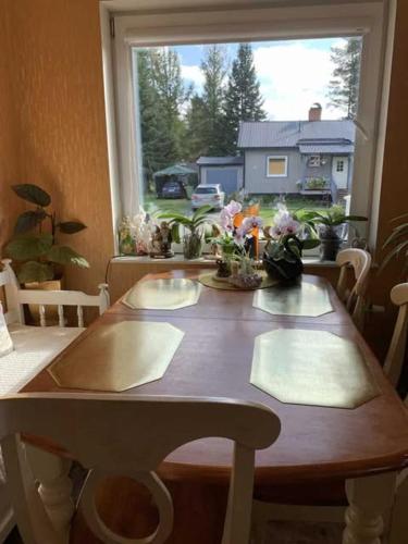 a wooden table in a room with a window at Fjällnära Villa i Vidsel in Vidsel