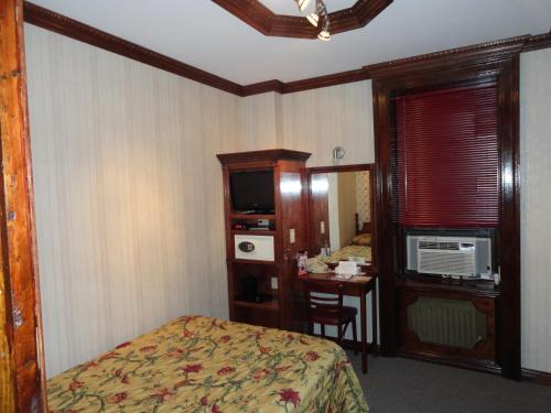 a hotel room with a bed and a desk with a table at Hotel 31 Extended Stay in New York