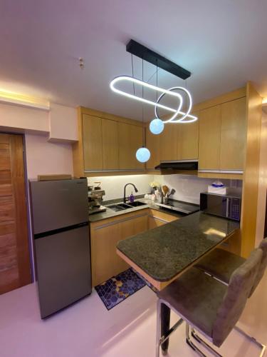 a kitchen with a stainless steel refrigerator and a table at Cozy Studio near Airport in Pusok