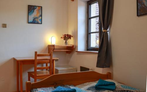 a bedroom with a bed and a desk and a window at Ubytování U Anděla in Raby