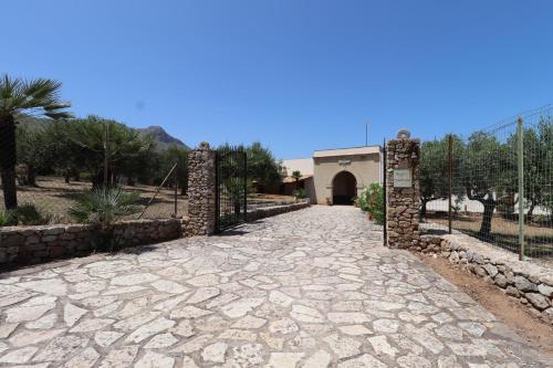 a stone walkway leading to a building with a gate at EVEN HAVEN Baglio in San Vito lo Capo