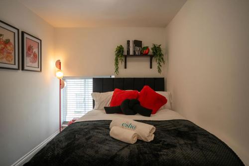 a bedroom with a large bed with red pillows at Cotswolds, 2Bed 1 Bath Historic Flat, Very Central in Cirencester