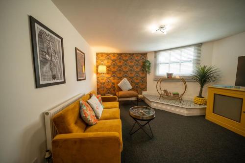 a living room with a couch and a tv at Cotswolds, 2Bed 1 Bath Historic Flat, Very Central in Cirencester