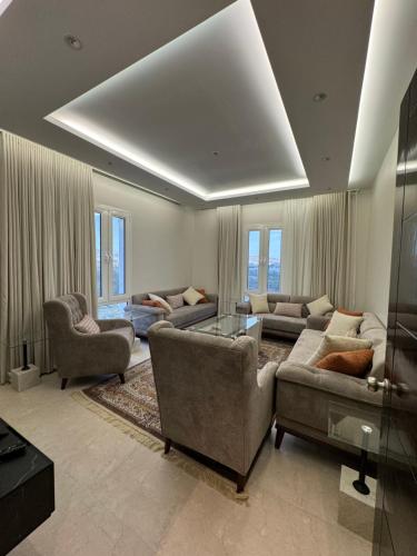 a living room with two couches and a table at شقة مميزة بتصميم حديث in Baljurashi