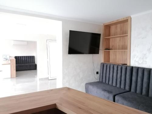a living room with a couch and a flat screen tv at гест хаус паркова 33 in Razgrad